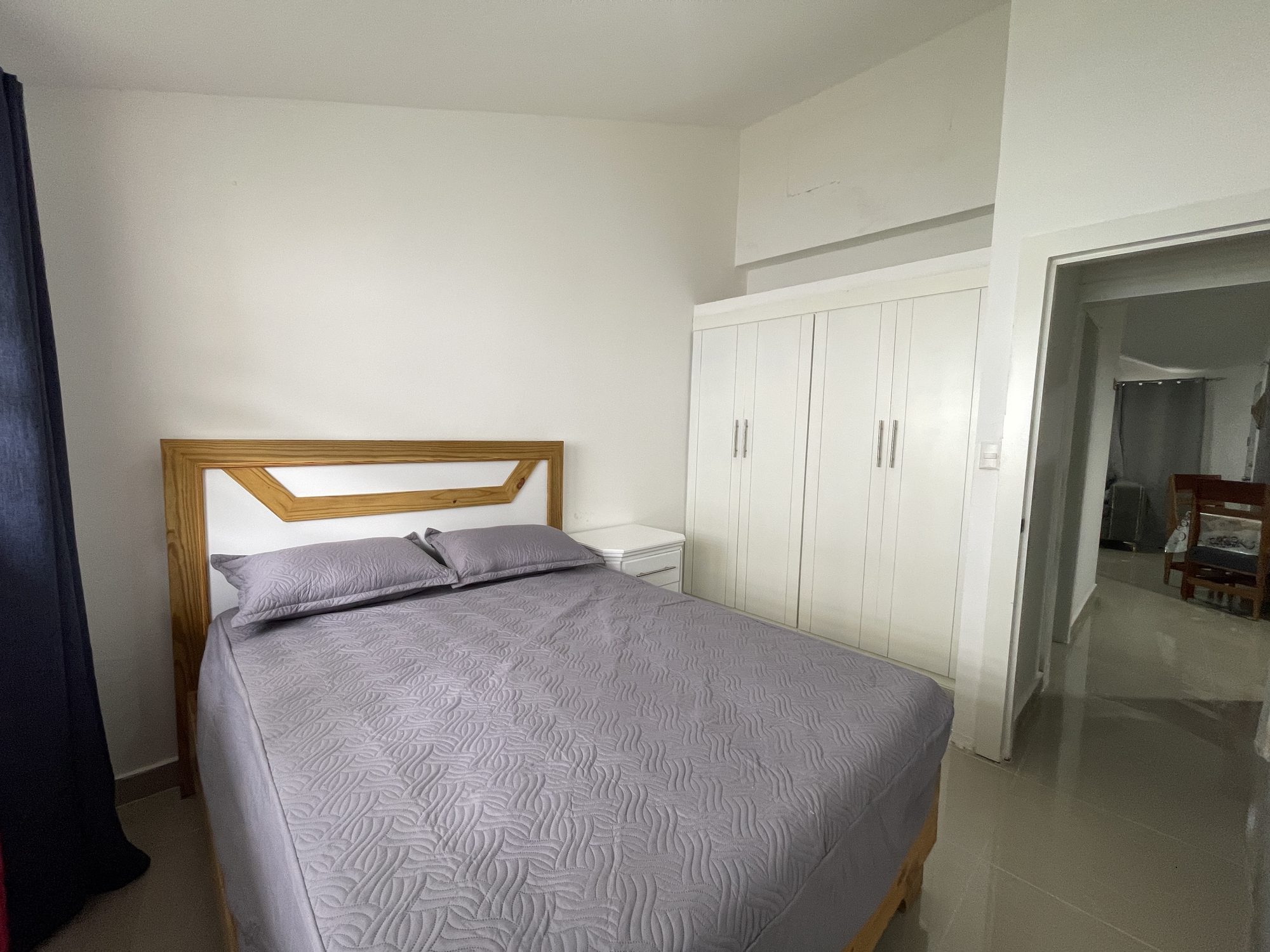 Una habitación con cama de madera y closets empotrados