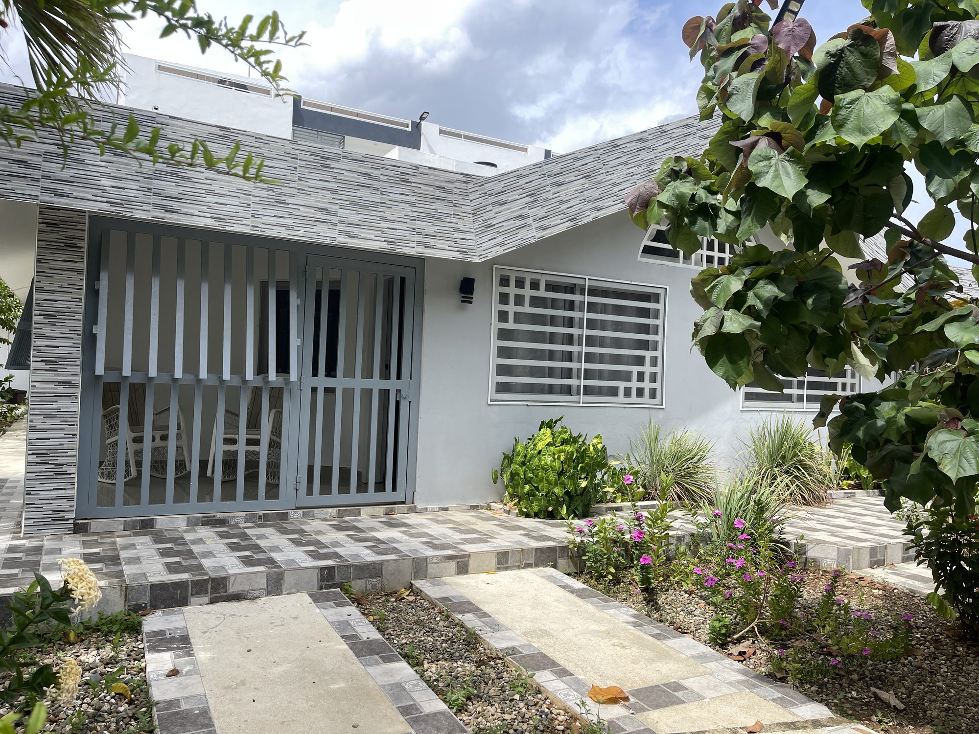 El frente de la casita y el camino del jardín