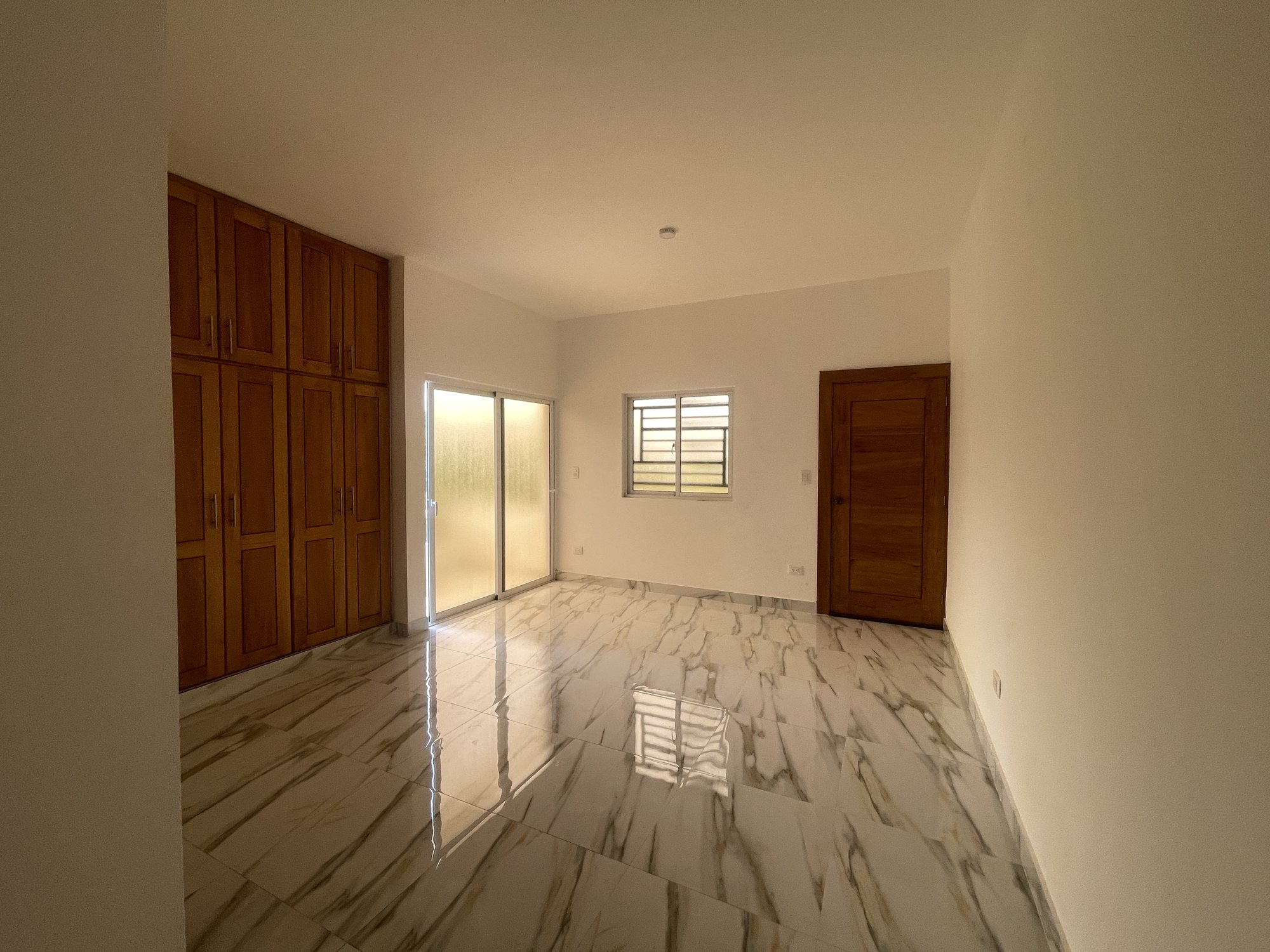 Una habitación con closets y puerta al balcón