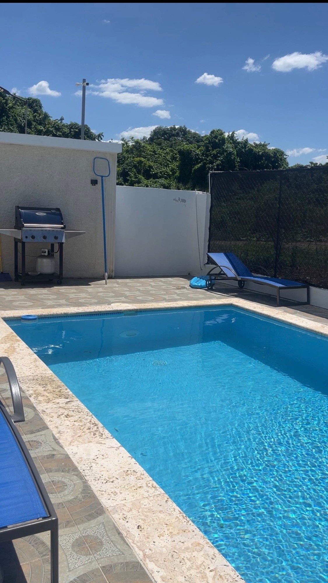 The pool at Residencial Montesino, with the barbecue beside it